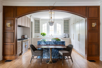 Transitional u-shaped medium tone wood floor and brown floor kitchen photo in Dallas with recessed-panel cabinets, beige cabinets, white backsplash, colored appliances, an island and white countertops