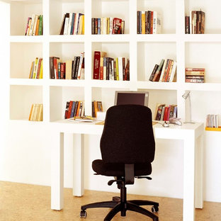 Photo of a small scandinavian study room in Other with white walls, cork floors, no fireplace, a freestanding desk and brown floor.