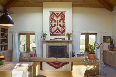 Example of a large trendy open concept concrete floor living room design in Santa Barbara with white walls, a standard fireplace and a stone fireplace