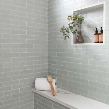 The shower features a shampoo niche, a sitting bench and a shower curb outlined