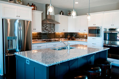 Inspiration for a mid-sized transitional l-shaped dark wood floor and brown floor eat-in kitchen remodel in Minneapolis with a double-bowl sink, shaker cabinets, white cabinets, granite countertops, brown backsplash, ceramic backsplash, stainless steel appliances and an island