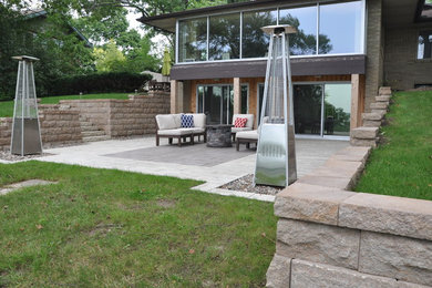 Mid-sized trendy backyard concrete paver patio photo in Other with a fire pit and no cover