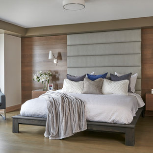 Large contemporary master bedroom in Toronto with beige walls, medium hardwood floors, a hanging fireplace, a metal fireplace surround and brown floor.