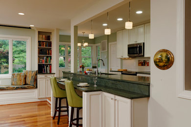 Eat-in kitchen - contemporary galley eat-in kitchen idea in DC Metro with raised-panel cabinets, white cabinets, granite countertops, beige backsplash, ceramic backsplash and stainless steel appliances