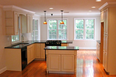 This is an example of a traditional kitchen in Philadelphia with light wood cabinets and with island.