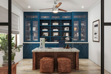 Ejemplo de despacho de estilo de casa de campo de tamaño medio con paredes azules, suelo de madera clara, escritorio independiente y suelo beige