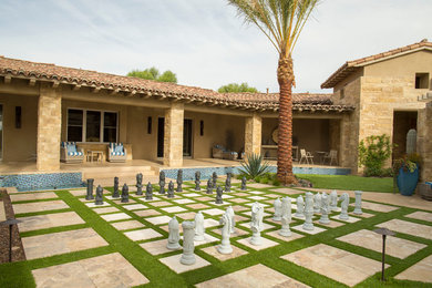 Example of a mid-sized transitional beige two-story adobe house exterior design in Other with a clipped gable roof and a shingle roof
