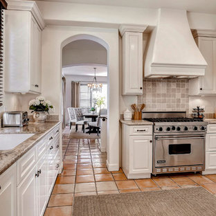 Mid-sized transitional kitchen pantry photos - Inspiration for a mid-sized transitional terra-cotta floor kitchen pantry remodel in Santa Barbara with a drop-in sink, white cabinets, granite countertops, beige backsplash, stone tile backsplash, stainless steel appliances and no island