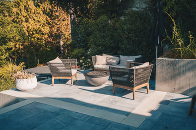 Mid-sized trendy backyard concrete paver patio photo in Vancouver with a fire pit and no cover