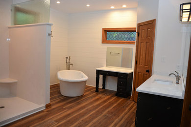 Large farmhouse master white tile brown floor and laminate floor bathroom photo in Indianapolis with raised-panel cabinets, black cabinets, white walls, an undermount sink, quartz countertops and white countertops
