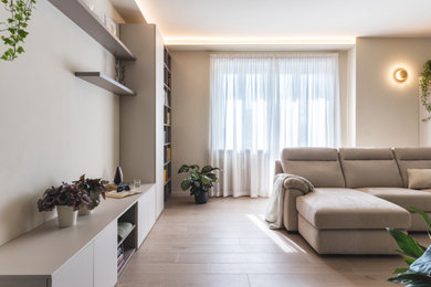 Example of a large minimalist open concept porcelain tile living room library design in Turin with beige walls
