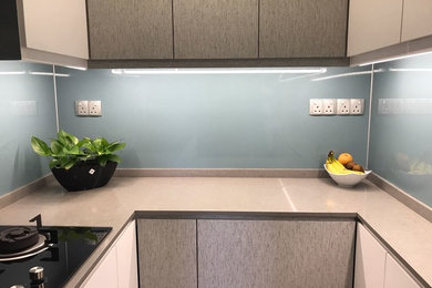 This is an example of a mid-sized contemporary u-shaped eat-in kitchen in Singapore with blue splashback and multiple islands.
