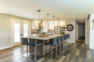 Mid-sized trendy vinyl floor, brown floor and wood ceiling kitchen photo in Seattle with an undermount sink, shaker cabinets, quartzite countertops, black backsplash, mosaic tile backsplash, stainless steel appliances, an island and gray countertops