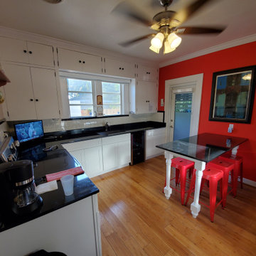 Contemporary Kitchen Remodel With White Cabinets and Black Countertop