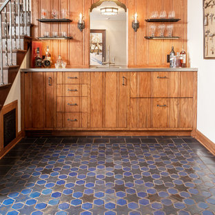 ミネアポリスの小さい地中海スタイルのおしゃれなウェットバー (フラットパネル扉のキャビネット、ステンレスカウンター、木材のキッチンパネル、セラミックタイルの床、中間色木目調キャビネット、マルチカラーの床) の写真