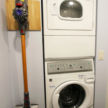 White Laundry Room with Storage and Stacked Washer & Dryer