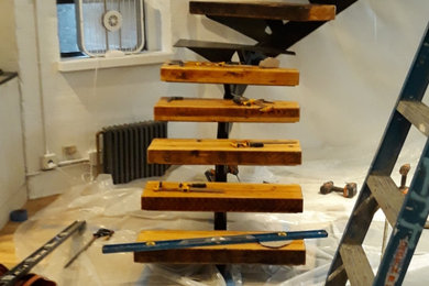Imagen de escalera curva moderna de tamaño medio sin contrahuella con escalones de madera y barandilla de varios materiales