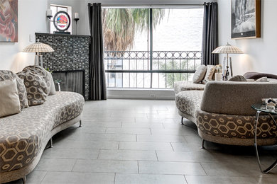 ロサンゼルスにある高級な広いコンテンポラリースタイルのおしゃれなリビング (磁器タイルの床、コーナー設置型暖炉、グレーの床) の写真