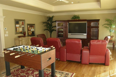 Inspiration for a mid-sized transitional light wood floor family room remodel in Little Rock with beige walls, no fireplace and a media wall
