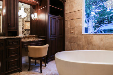 Elegant master beige tile and black tile beige floor bathroom photo in Orlando with beaded inset cabinets, dark wood cabinets, beige walls, a drop-in sink, granite countertops and a hinged shower door