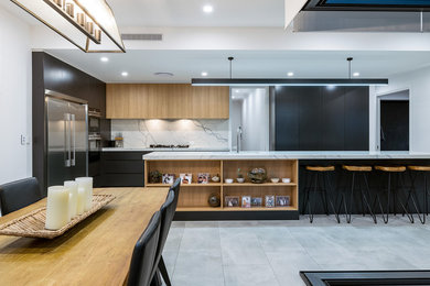 Inspiration for a large contemporary l-shaped eat-in kitchen in Brisbane with an undermount sink, light wood cabinets, marble benchtops, white splashback, marble splashback, stainless steel appliances, porcelain floors, with island, grey floor, white benchtop and flat-panel cabinets.
