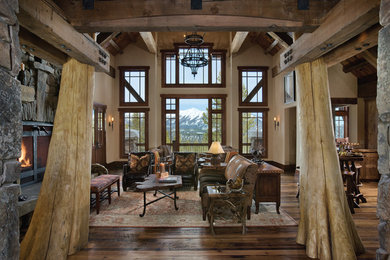 Example of a mountain style open concept living room design in Other with beige walls and a stone fireplace