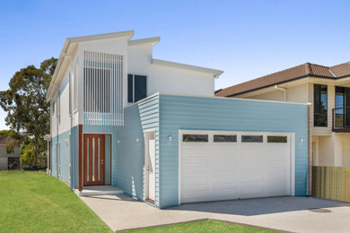 Inspiration for a mid-sized contemporary two-storey blue house exterior in Brisbane with concrete fiberboard siding, a gable roof, a metal roof, a grey roof and board and batten siding.