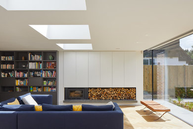 Photo of a mid-sized contemporary living room in London with white walls, light hardwood floors, beige floor, a metal fireplace surround and a wood stove.