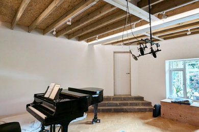Inspiration for a medium sized midcentury open plan living room in Hertfordshire with a music area, bamboo flooring and exposed beams.