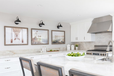 This is an example of a large beach style eat-in kitchen in San Diego with shaker cabinets, beige splashback, stainless steel appliances and with island.