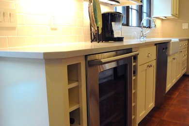 Enclosed kitchen - mid-sized traditional galley ceramic tile enclosed kitchen idea in Orange County with a farmhouse sink, shaker cabinets, white cabinets, quartz countertops, white backsplash, subway tile backsplash, stainless steel appliances and no island