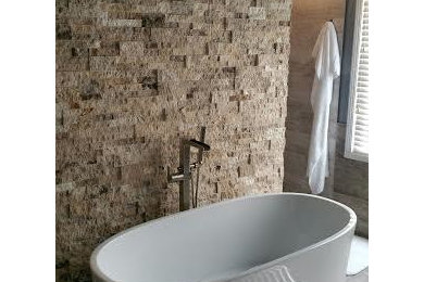 アトランタにあるコンテンポラリースタイルのおしゃれな浴室 (置き型浴槽、ベージュのタイル、茶色いタイル、マルチカラーのタイル、大理石の床) の写真