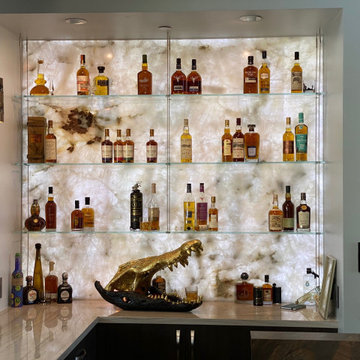 LED-backlit onyx stone bar with floating glass shelves