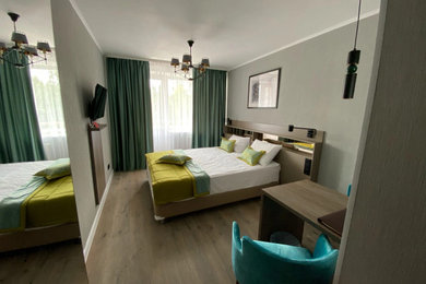 Идея дизайна: гостевая спальня (комната для гостей) в современном стиле с серыми стенами и полом из ламината