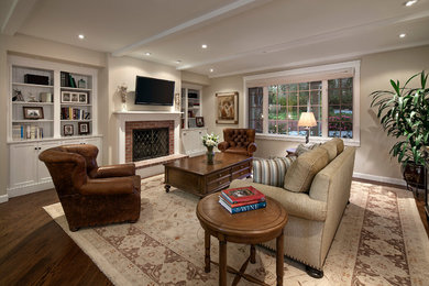 Family room - mid-sized cottage open concept dark wood floor family room idea in Santa Barbara with beige walls, a standard fireplace, a brick fireplace and a wall-mounted tv