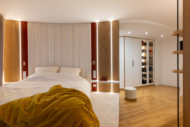 Diseño de dormitorio principal y blanco y madera contemporáneo extra grande con paredes blancas, suelo de madera clara y suelo marrón