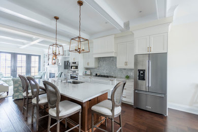 Example of a transitional galley dark wood floor and brown floor kitchen design in Toronto with an undermount sink, shaker cabinets, white cabinets, gray backsplash, stainless steel appliances and white countertops