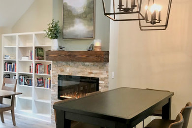 Mid-sized transitional loft-style laminate floor, brown floor and vaulted ceiling living room library photo in Portland with green walls, a standard fireplace, a stacked stone fireplace and no tv