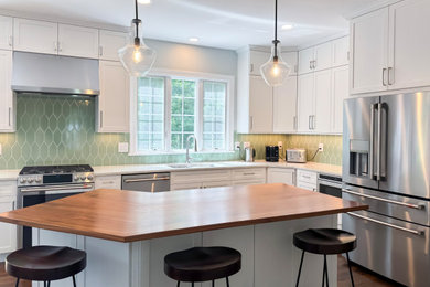 Inspiration for a mid-sized transitional l-shaped dark wood floor kitchen remodel in Boston with an undermount sink, shaker cabinets, white cabinets, wood countertops, green backsplash, ceramic backsplash, stainless steel appliances, an island and white countertops