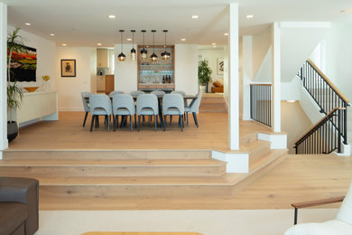 Example of a large danish light wood floor great room design in San Luis Obispo with white walls and a ribbon fireplace
