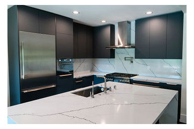 Inspiration for a large modern l-shaped dark wood floor and black floor eat-in kitchen remodel in Los Angeles with a drop-in sink, recessed-panel cabinets, gray cabinets, quartzite countertops, stone slab backsplash, stainless steel appliances, an island and white countertops