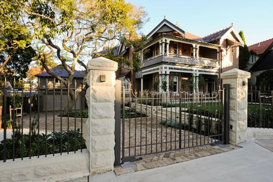 Large arts and crafts three-storey brick brown exterior in Sydney with a gable roof.