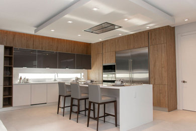 Foto de cocina minimalista con puertas de armario grises, una isla y encimeras blancas