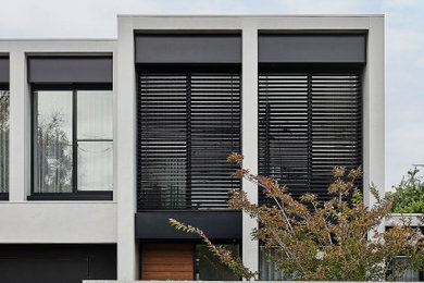 Foto della villa grigia contemporanea a due piani di medie dimensioni con rivestimento in cemento, tetto piano e copertura in metallo o lamiera