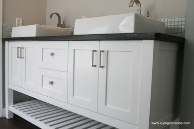 Bathroom - mid-sized contemporary master green tile and glass tile porcelain tile bathroom idea in Charlotte with a vessel sink, flat-panel cabinets, white cabinets, granite countertops, a two-piece toilet and gray walls