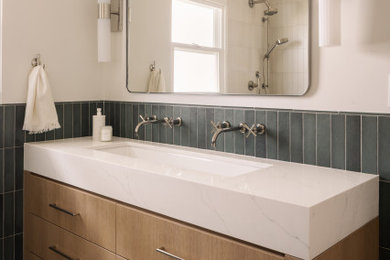 Inspiration for a mid-sized coastal green tile and ceramic tile gray floor and double-sink bathroom remodel in Orange County with flat-panel cabinets, light wood cabinets, white countertops, white walls, a trough sink and a built-in vanity