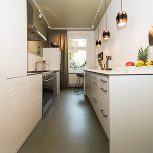 Выдающиеся фото от архитекторов и дизайнеров интерьера: маленькая отдельная, параллельная кухня в современном стиле с накладной раковиной, плоскими фасадами, белыми фасадами, столешницей из ламината, белым фартуком, техникой из нержавеющей стали, полом из линолеума, зеленым полом и белой столешницей без острова