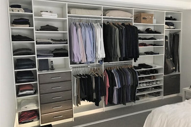This is an example of a large modern gender-neutral built-in wardrobe in Los Angeles with flat-panel cabinets.