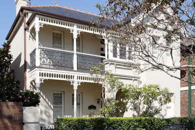 Photo of a large traditional two-storey stucco white exterior in Sydney with a gable roof.