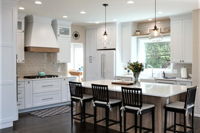 Open concept kitchen - large transitional l-shaped open concept kitchen idea in Denver with a farmhouse sink, shaker cabinets, quartz countertops, glass tile backsplash, white appliances, an island and white countertops